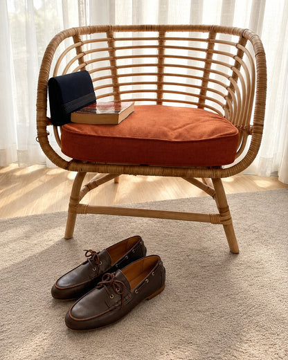 Riva Dark Brown beside a rattan chair